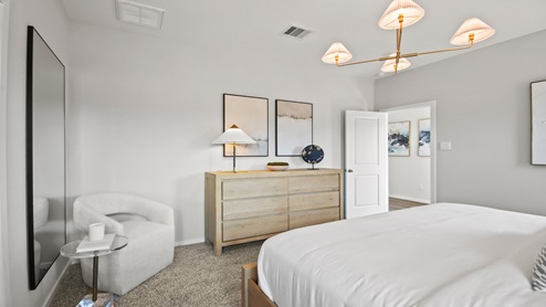 primary bedroom with large windows and carpet flooring