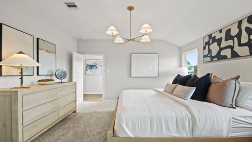 primary bedroom with large windows and carpet flooring