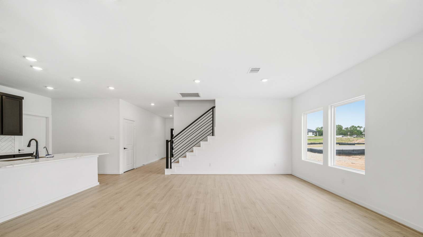 Spacious living area with vinyl flooring
