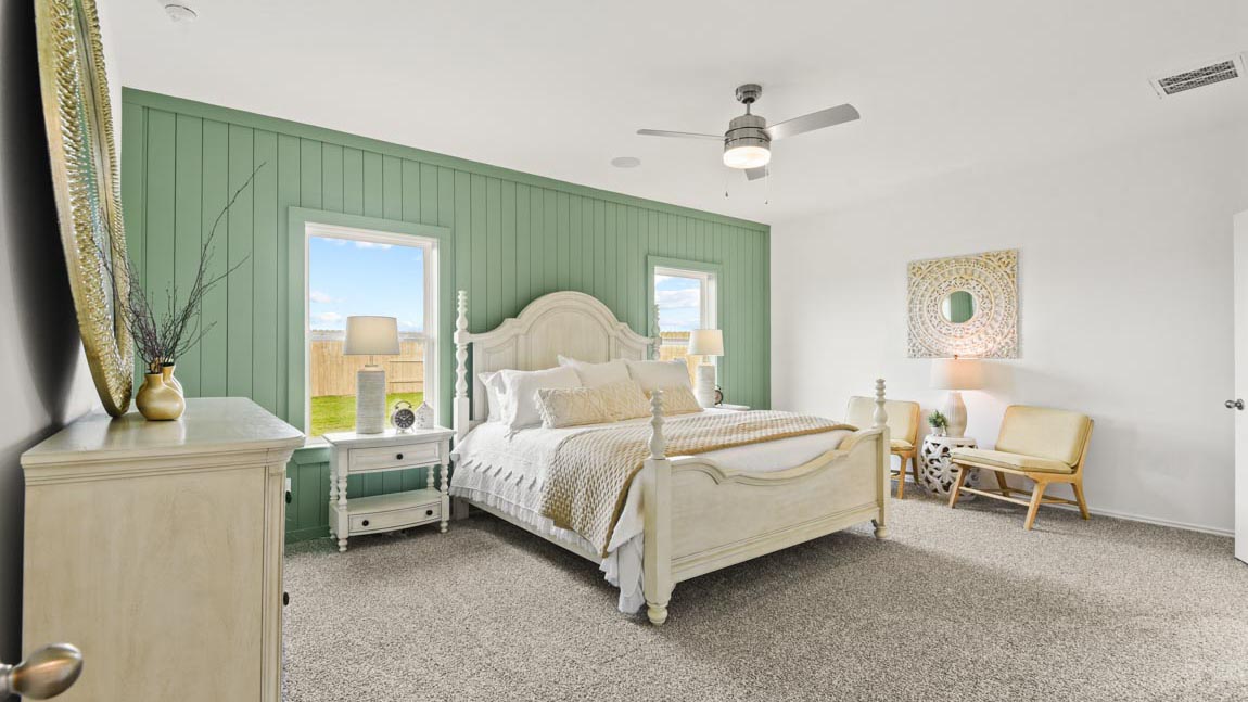 Primary bedroom with windows, white walls, and light carpet.
