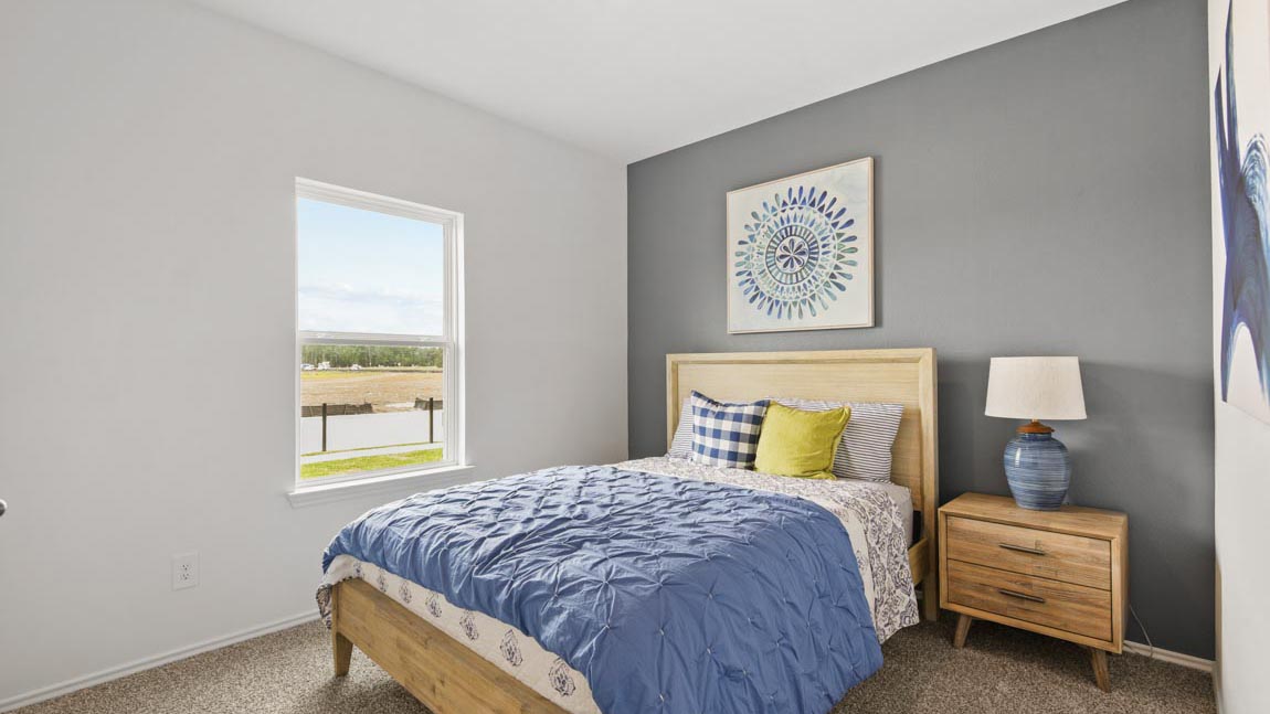Secondary bedroom with windows, white walls, and light carpet.