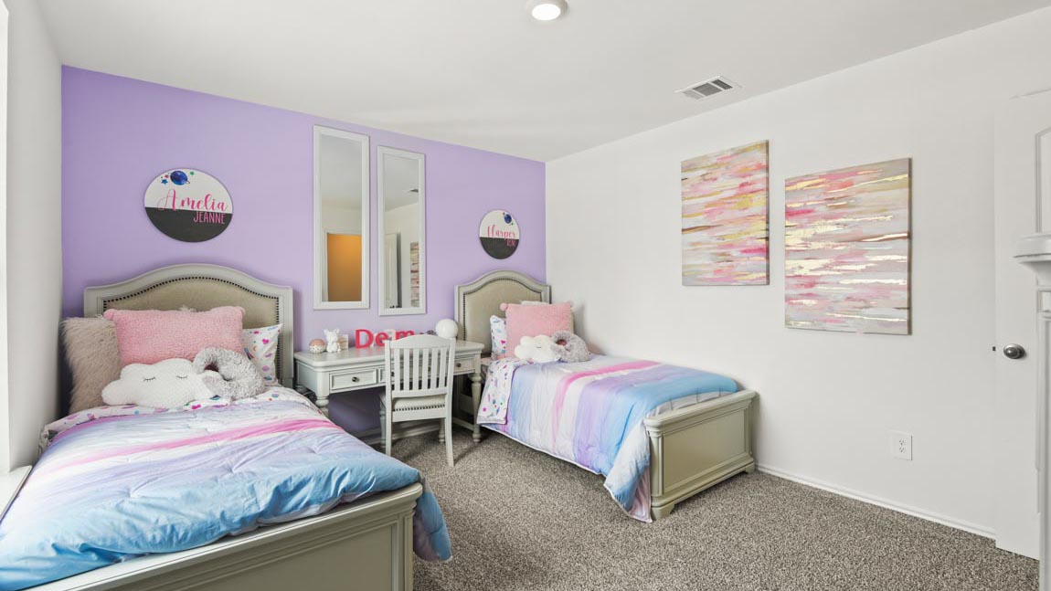 Secondary bedroom with windows, white walls, and light carpet.