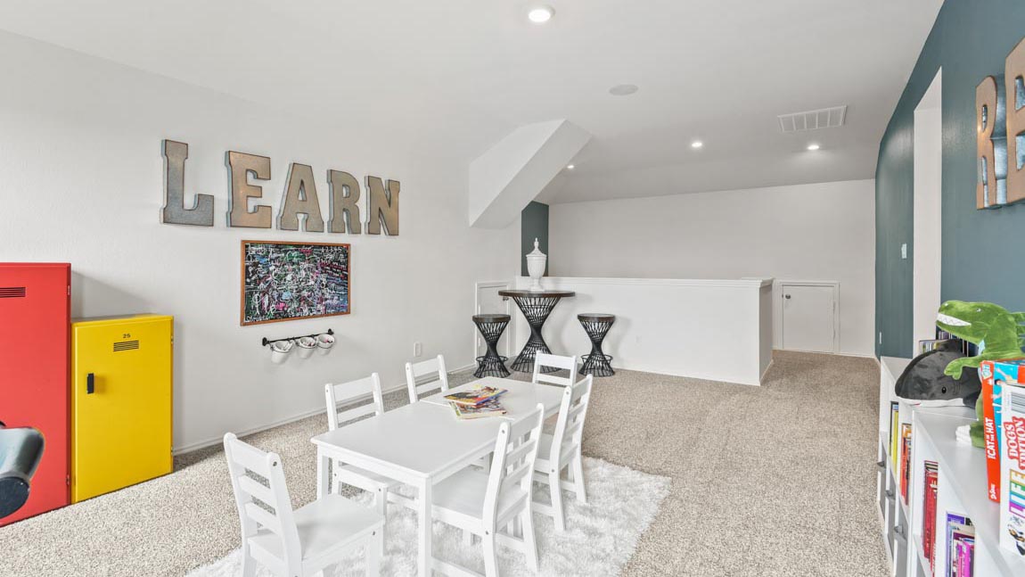 Large game room with windows, white walls, and light carpet.