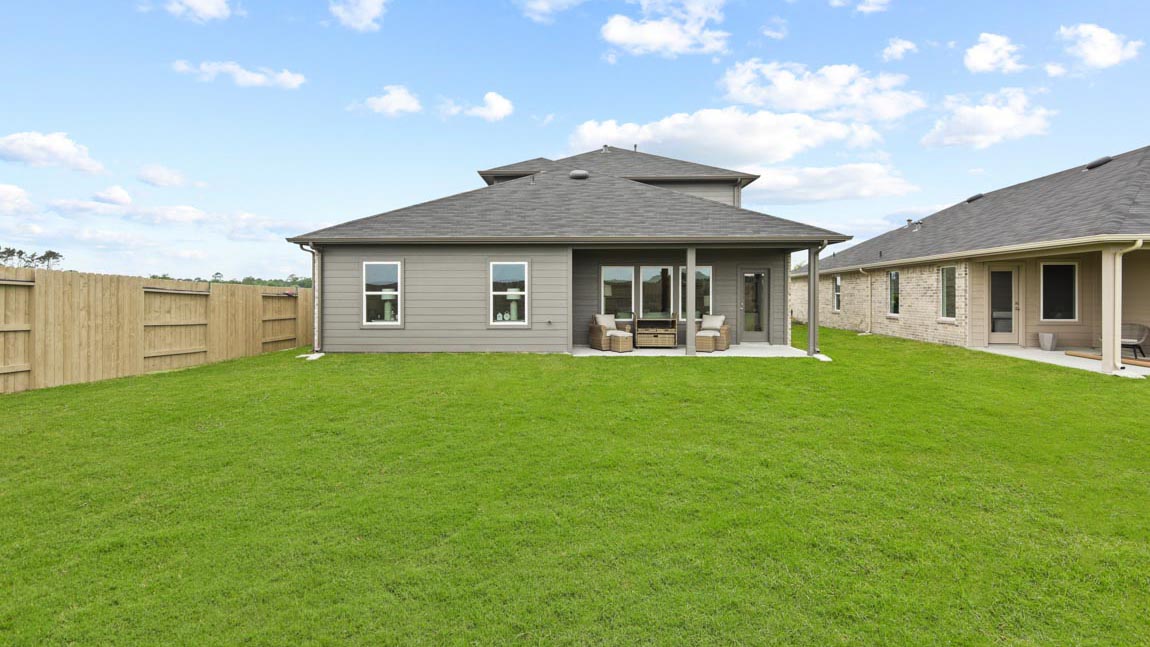 Landscaped backyard with a covered patio.