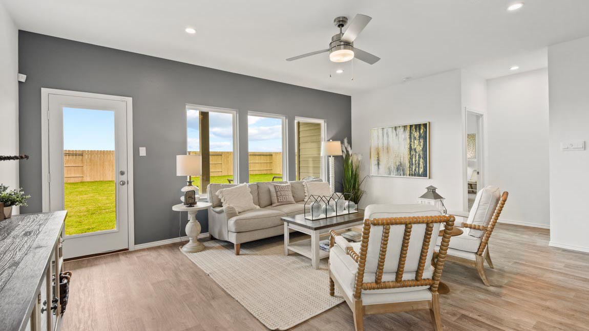 Open living room with windows, white walls, and vinyl wood flooring.