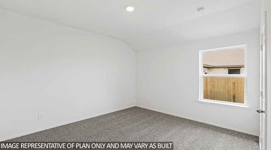 Secondary bedroom with carpet flooring and bright window.