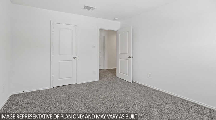 Secondary bedroom with carpet flooring.