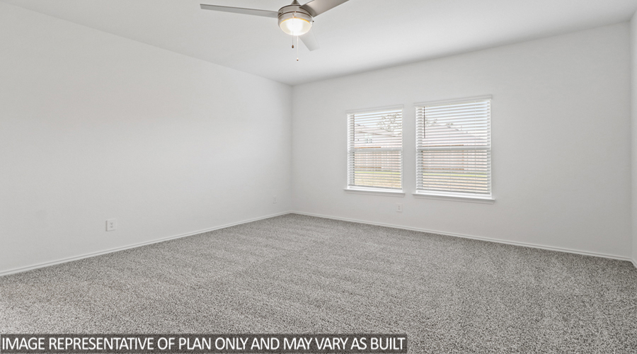 Primary bedroom with carpet flooring and a bright window.