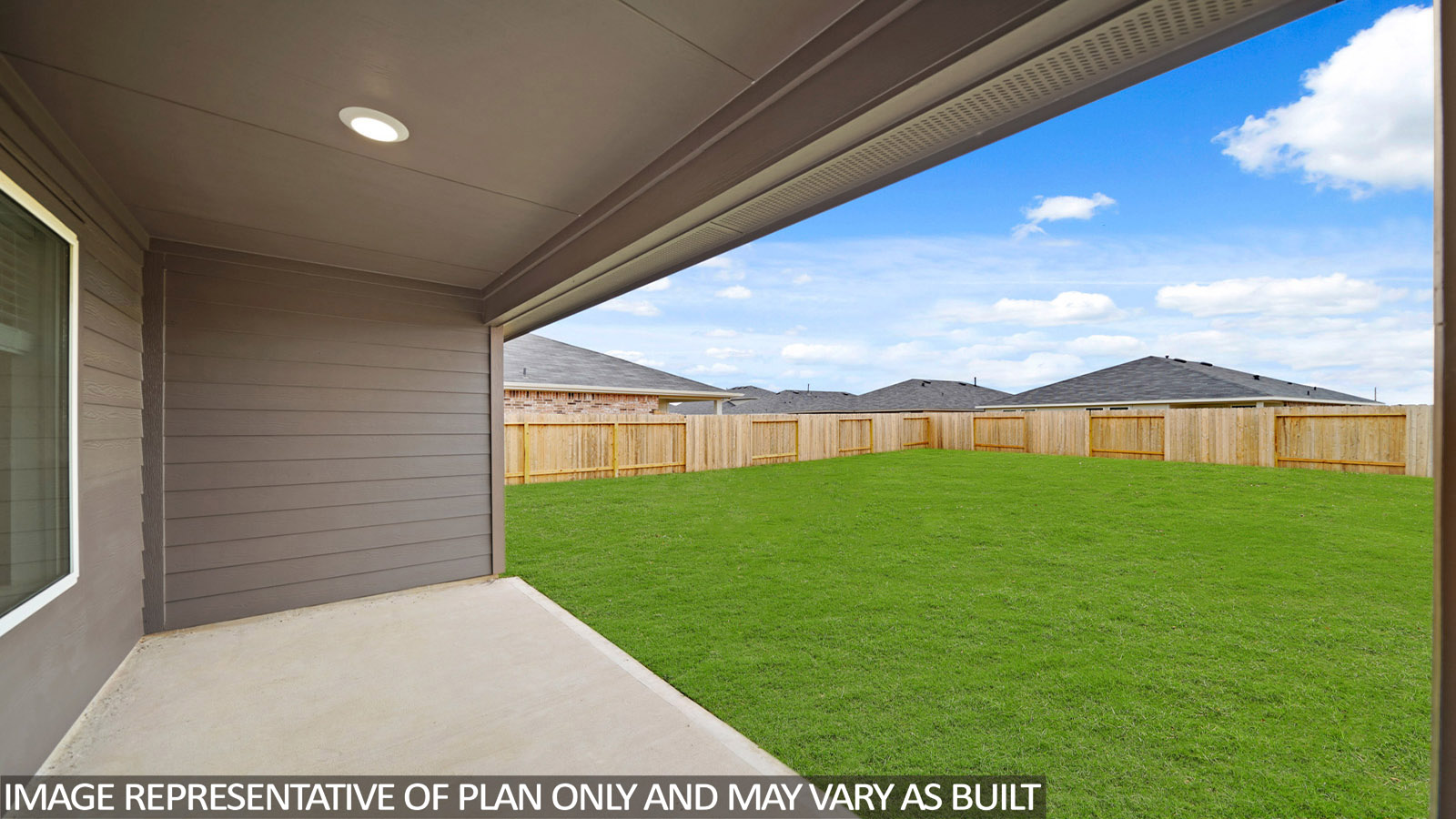 Spacious backyard with patio and overhead light.