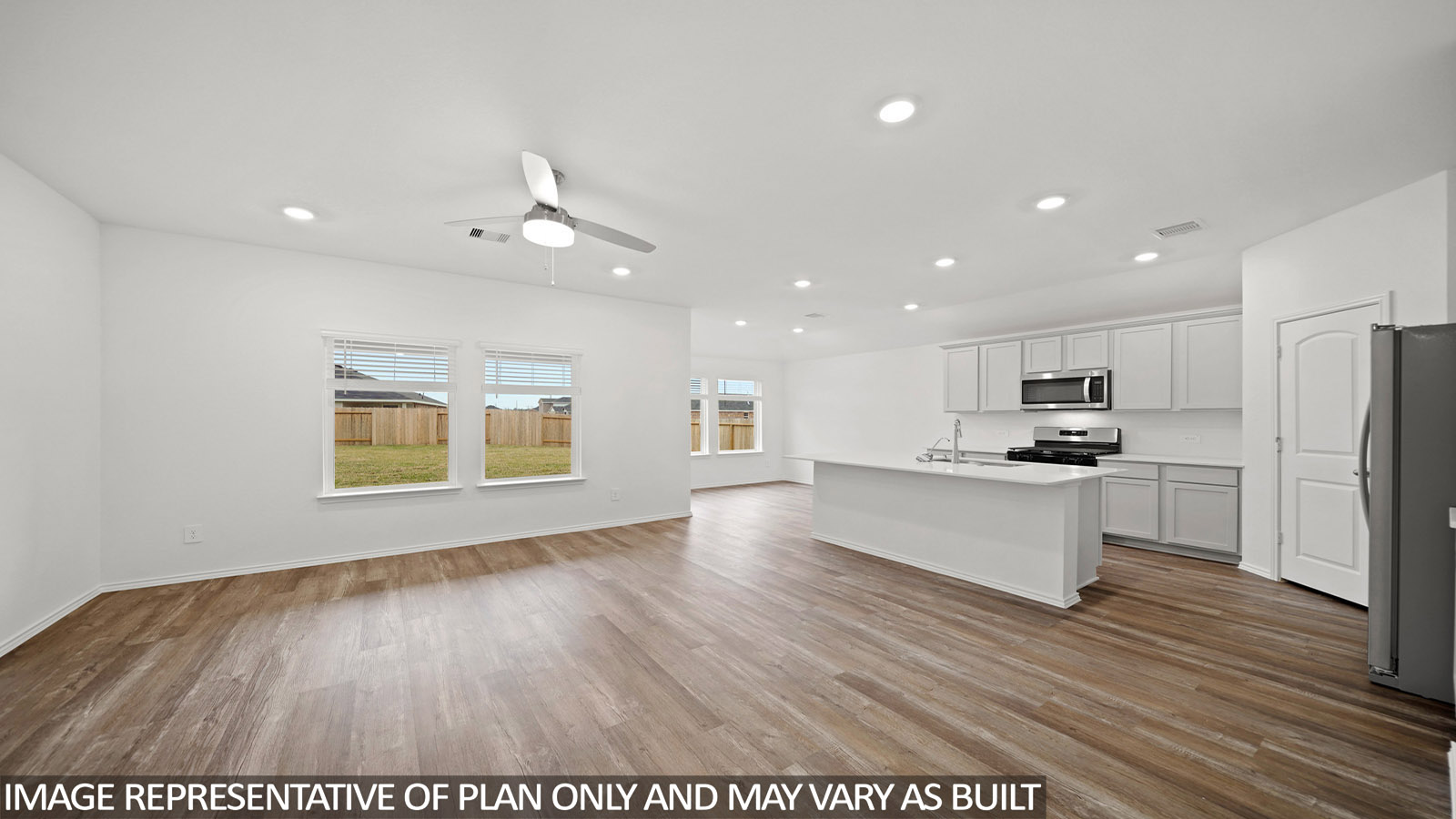 Open concept living and dining area with vinyl flooring and bright windows.