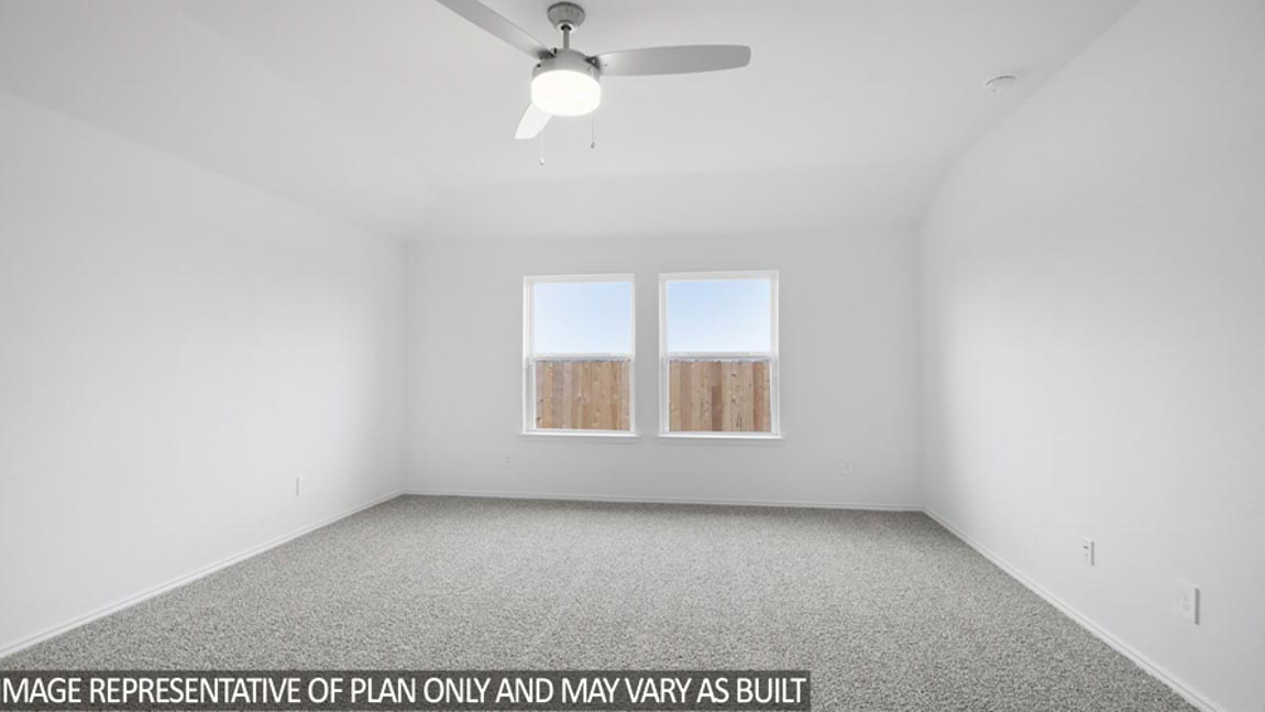 Primary bedroom with carpet flooring and bright windows.