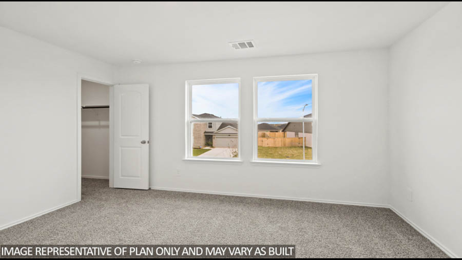 Secondary bedroom with carpet flooring, a bright window, and a tall closet.