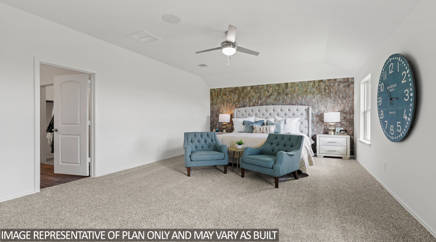 Primary bedroom with carpet flooring and bright windows.