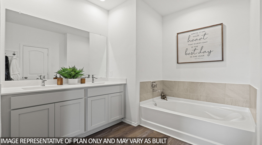 Primary bathroom with tile tub and double sink.