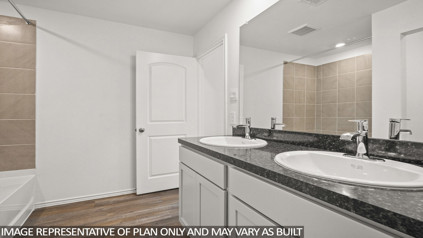 Primary bathroom with a double sink and a tile tub/shower combo.