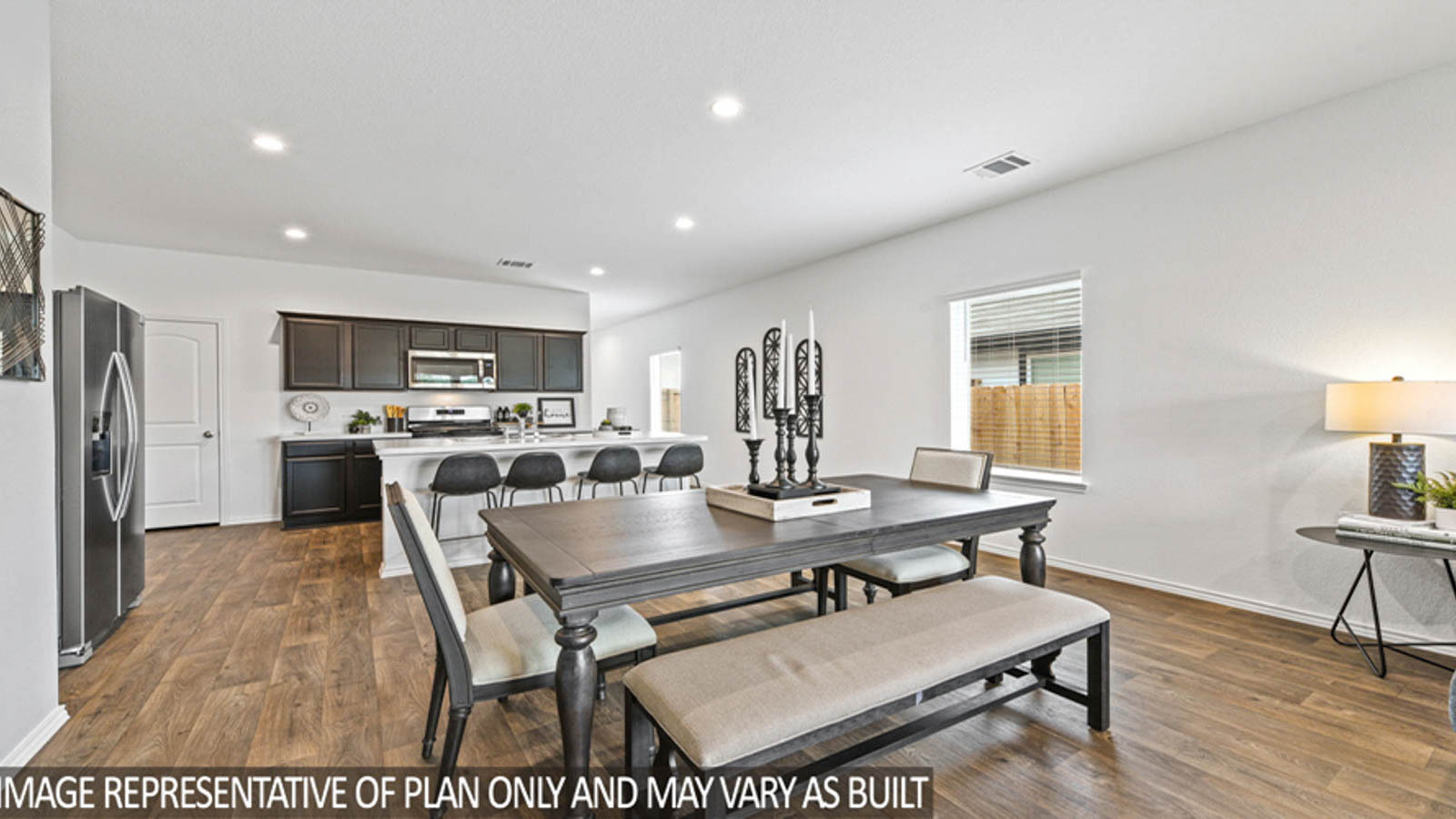 Open concept living and dining area with vinyl flooring and bright windows.