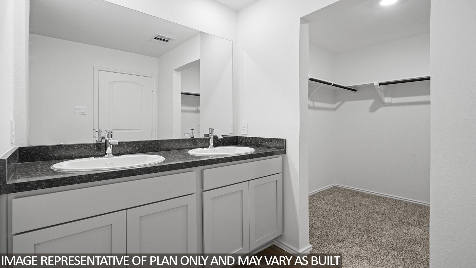 Primary bathroom with walk-in closet and double sink.