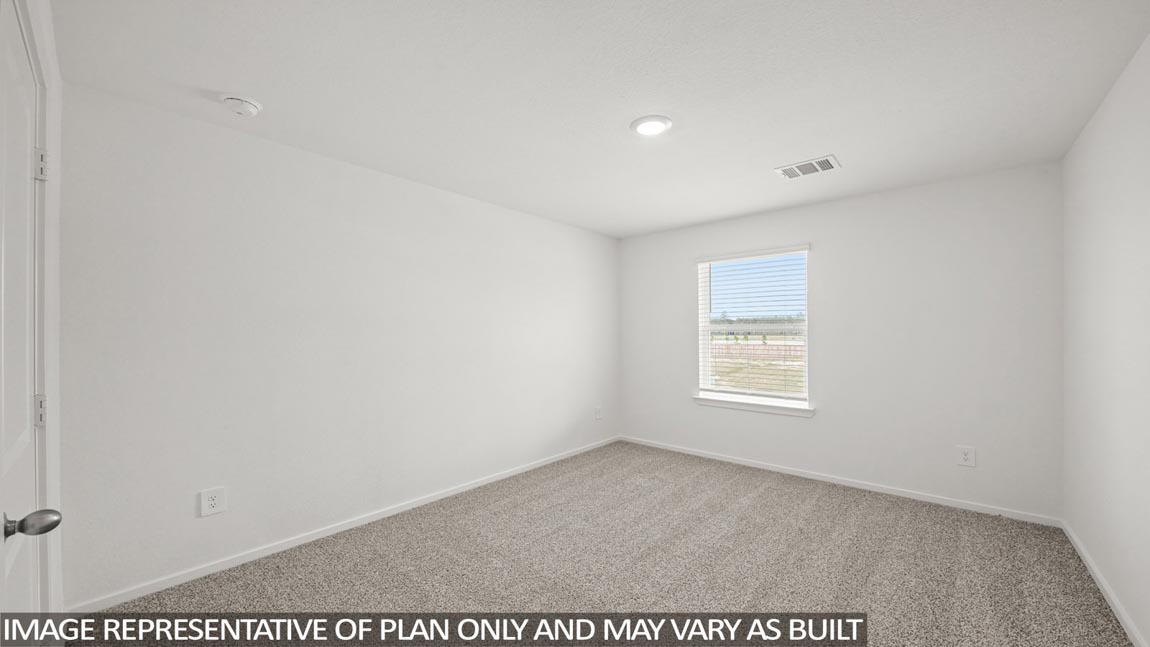 Secondary bedroom with carpet flooring