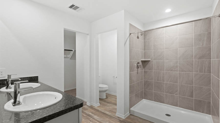 Primary bathroom with a standing shower and a separate toilet room.