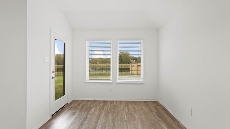 Breakfast area with vinyl flooring and bright windows.