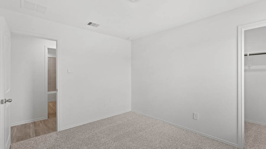 Secondary bedroom with carpet flooring.