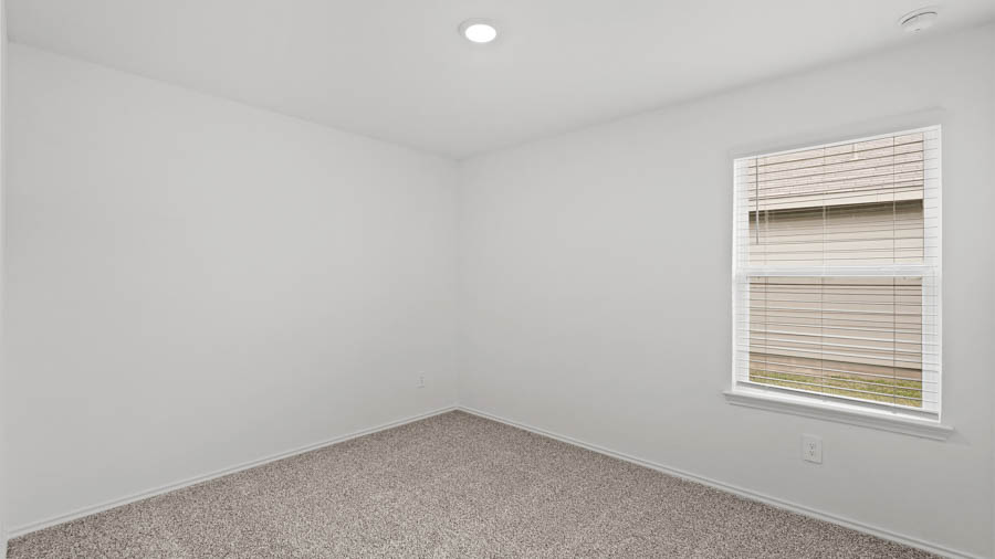 Secondary bedroom with carpet flooring and a window.