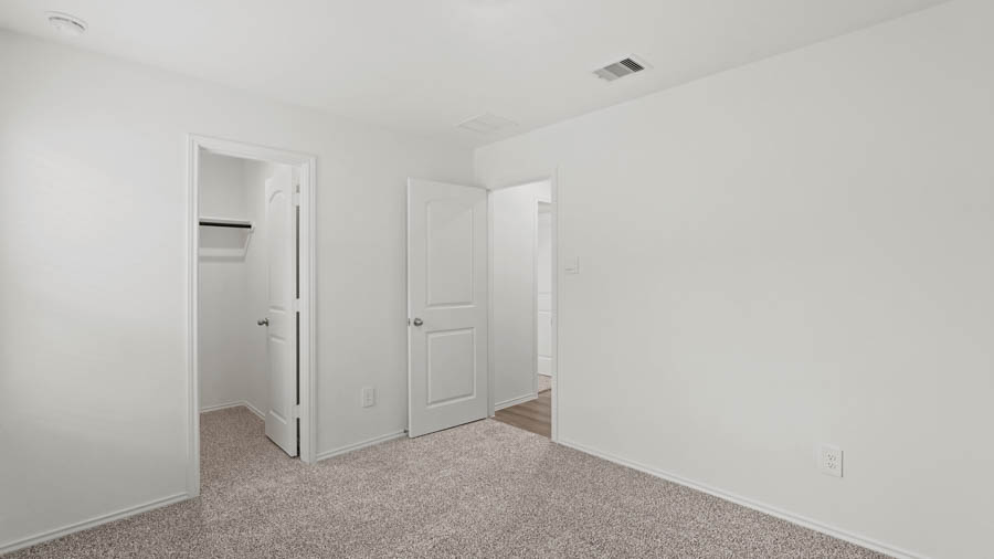 Secondary bedroom with carpet flooring.