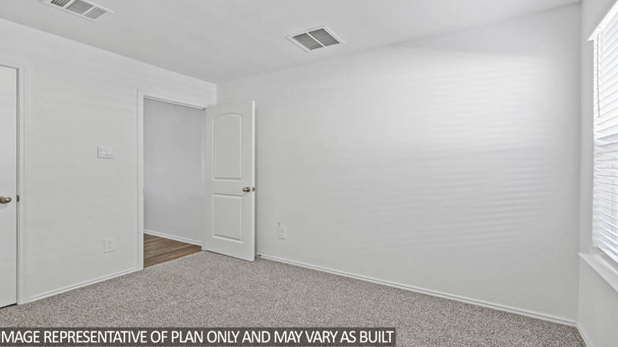 Secondary bedroom with carpet flooring