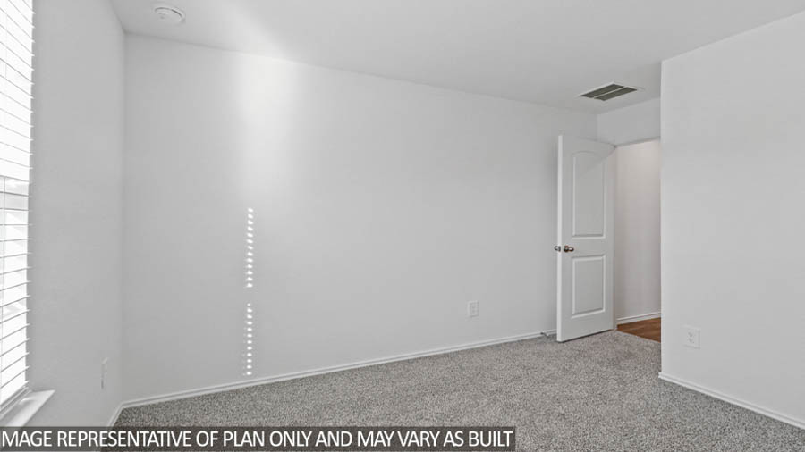 Secondary bedroom with carpet flooring.