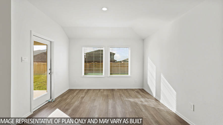 Dining area with vinyl flooring and bright windows.
