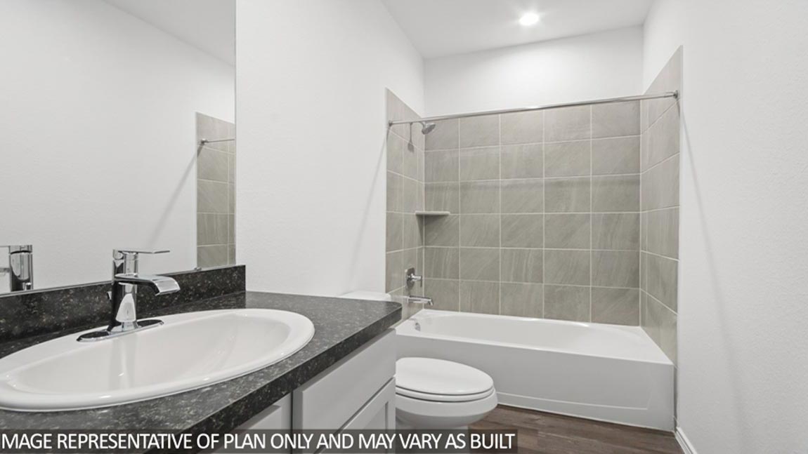 Family bathroom with stylish vanity, mirror, polished fixtures, cabinets, tub-shower combo in Harrington Trails