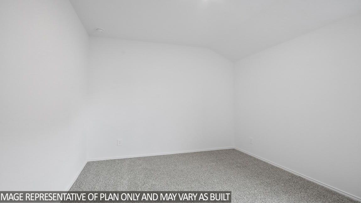 Secondary bedroom with a tall closet and carpet flooring.