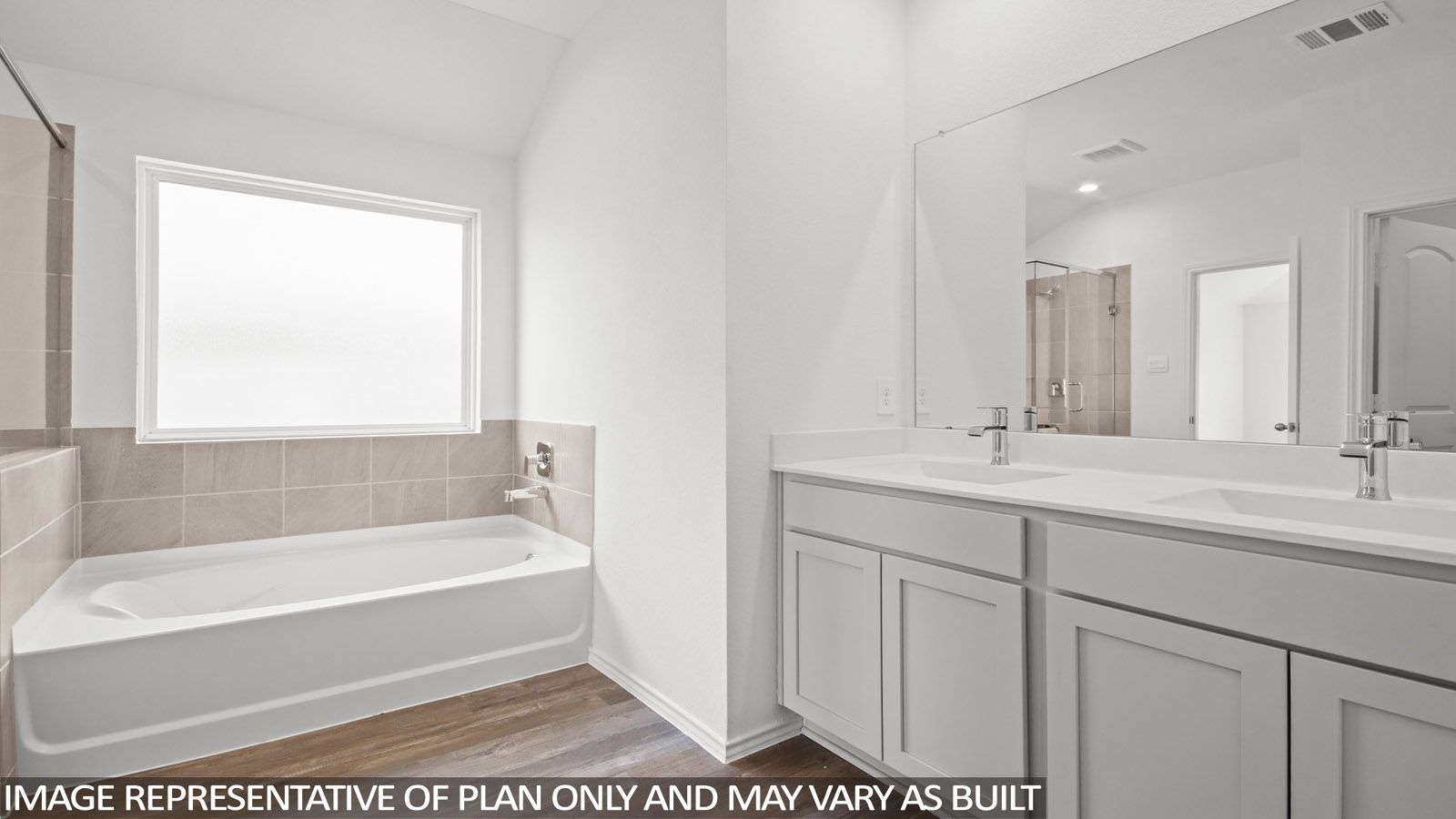 Primary bathroom with vinyl flooring, a frosted window, a tile tub, and a double sink.