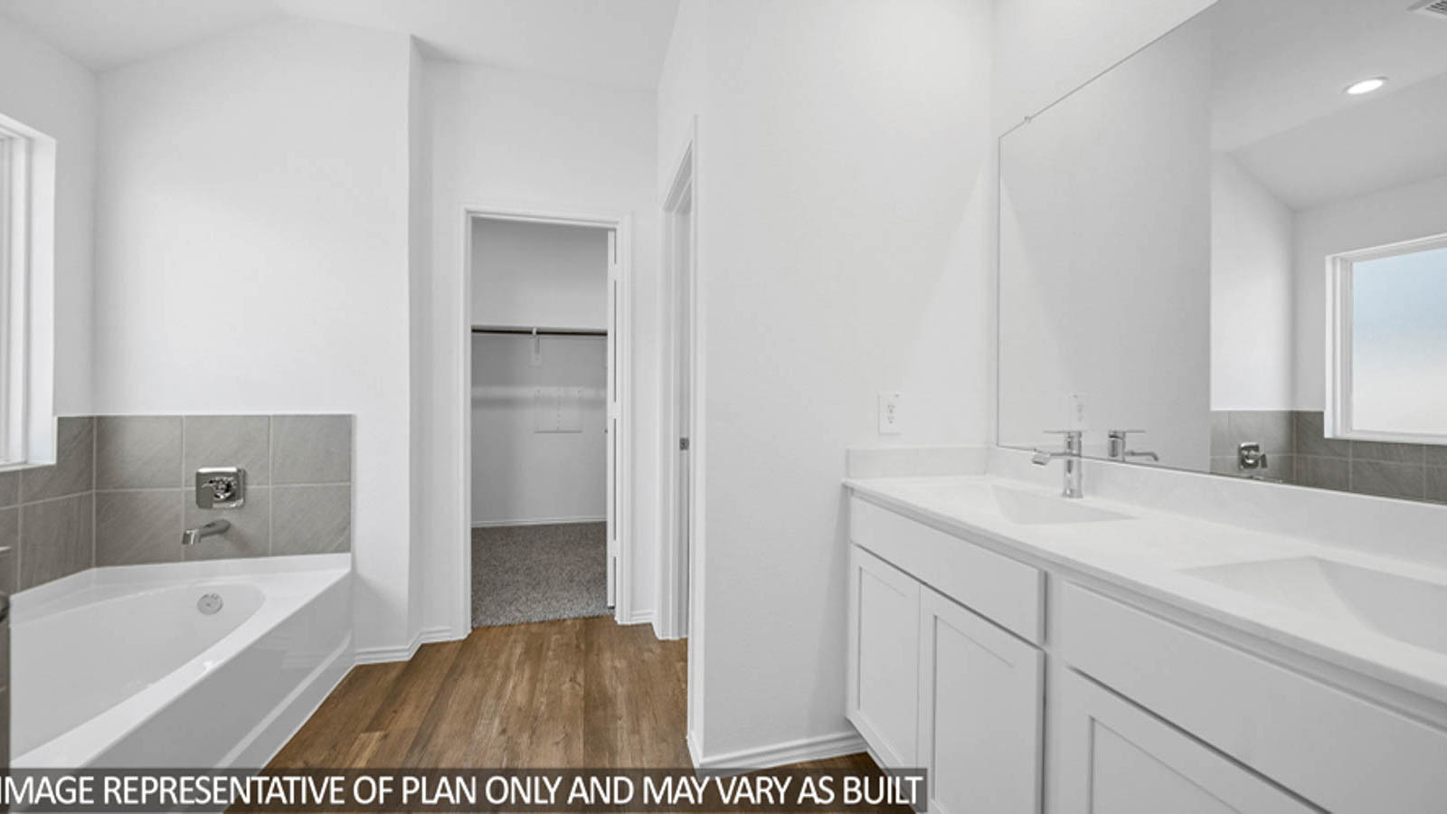 Primary bathroom with a separate toilet room and a walk-in closet with carpet flooring.
