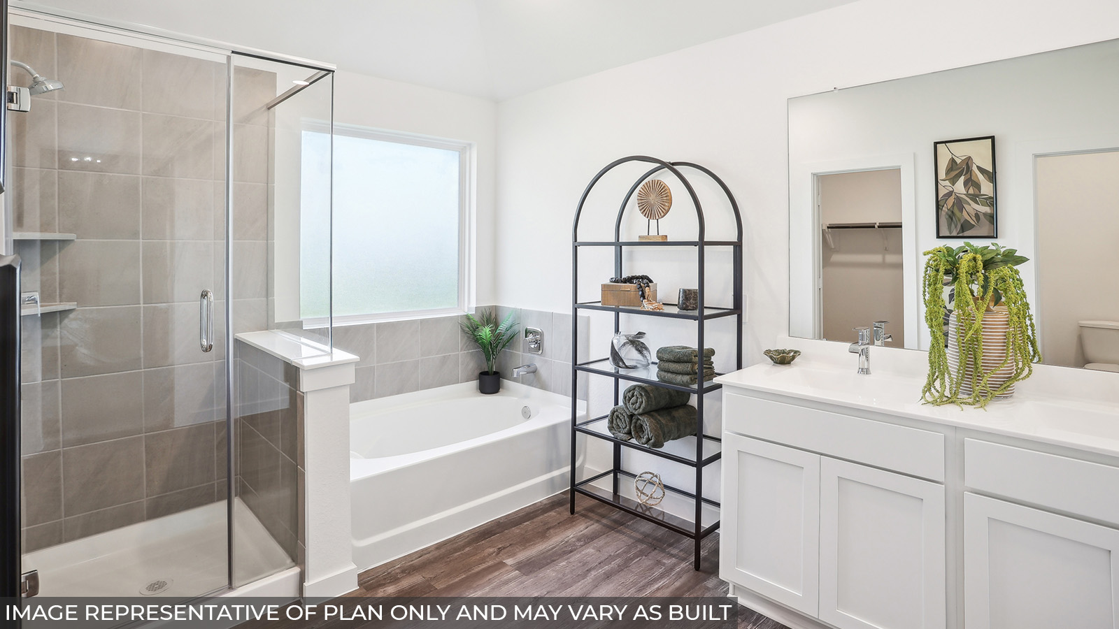 Staged primary bathroom with a double sink, a frosted window, a standing shower, and a tile tub.