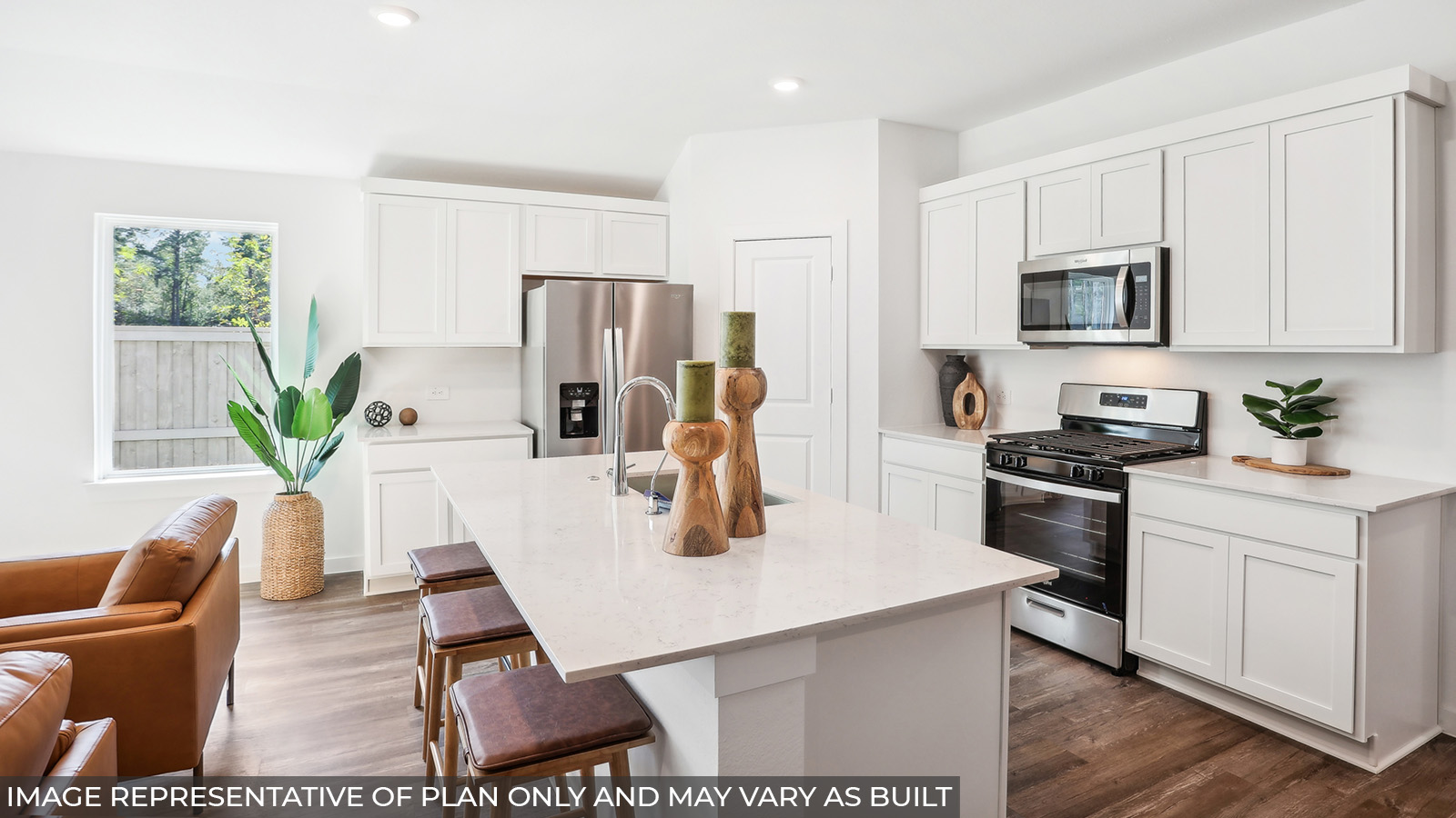 Staged kitchen with stainless-steel appliances and an island.