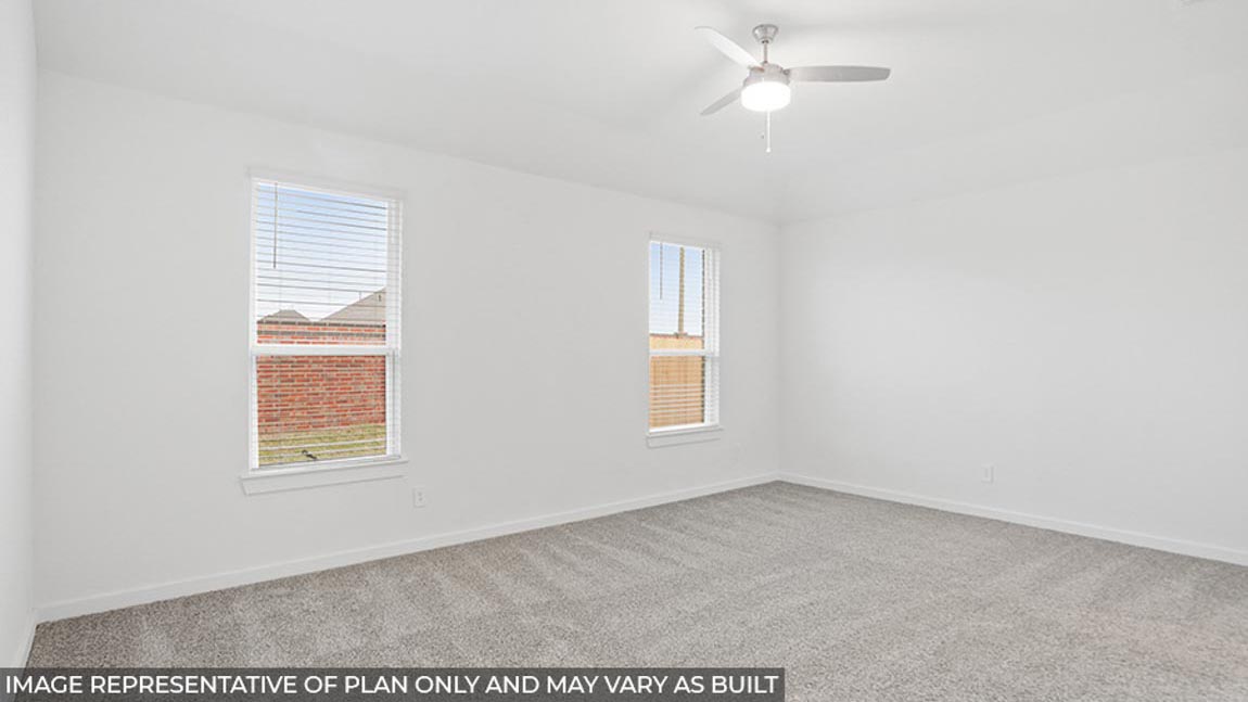 Primary bedroom with carpet flooring, a ceiling fan, and bright windows.