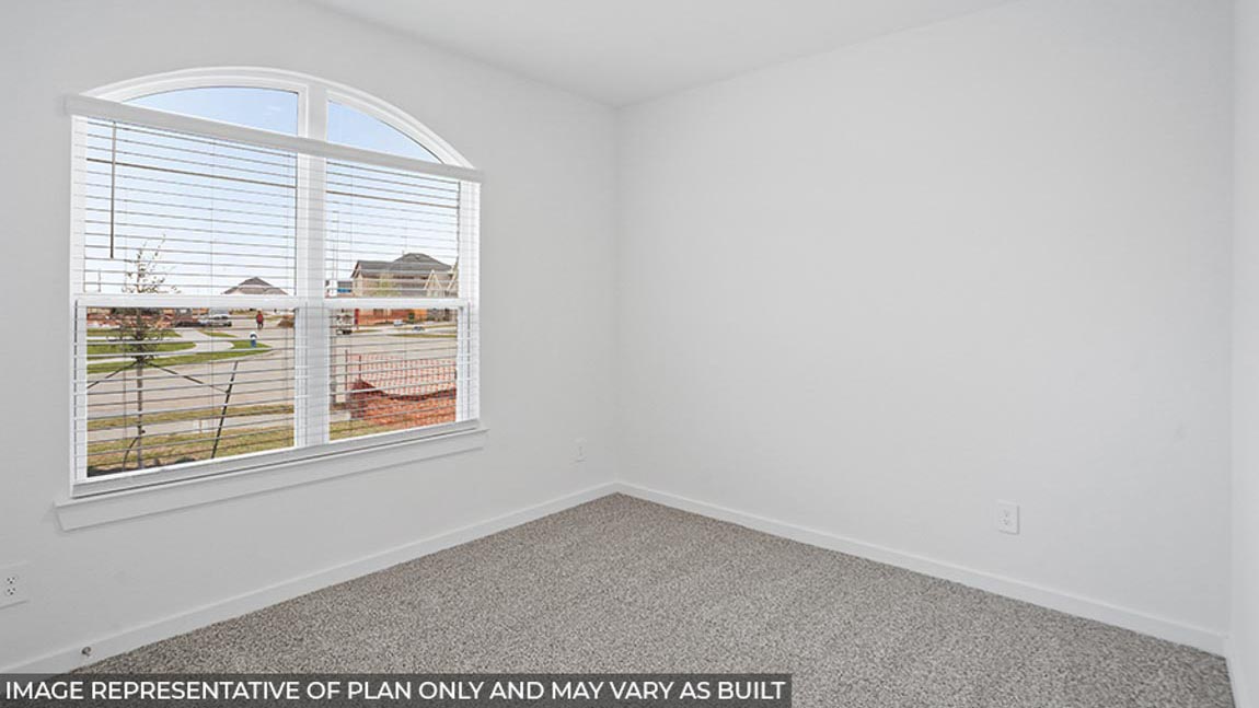 Secondary bedroom with carpet flooring and bright windows.