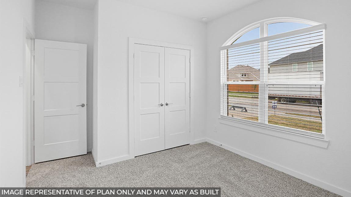 Secondary bedroom with carpet flooring and bright windows.