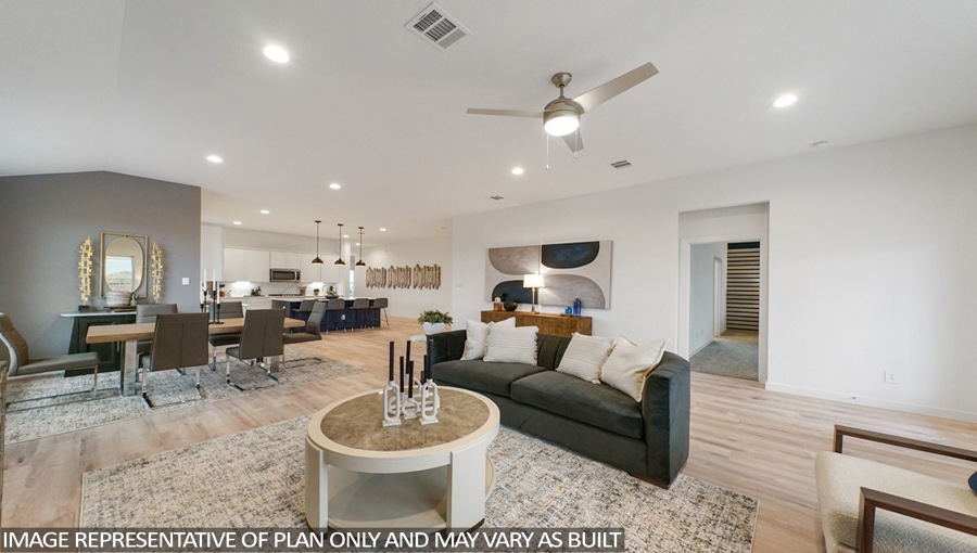 Staged open concept living and dining area with vinyl flooring and bright windows.
