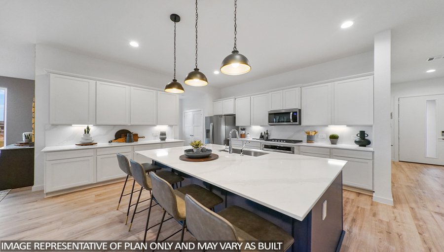 Staged kitchen with an island and stainless-steel appliances.
