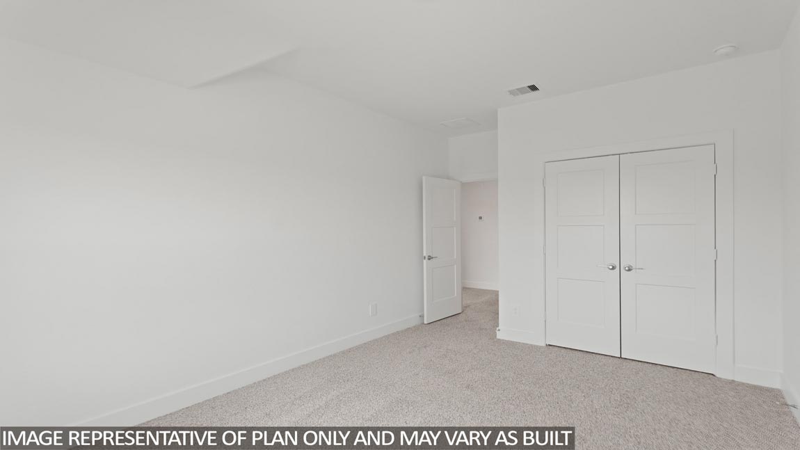 Secondary bedroom with carpet flooring