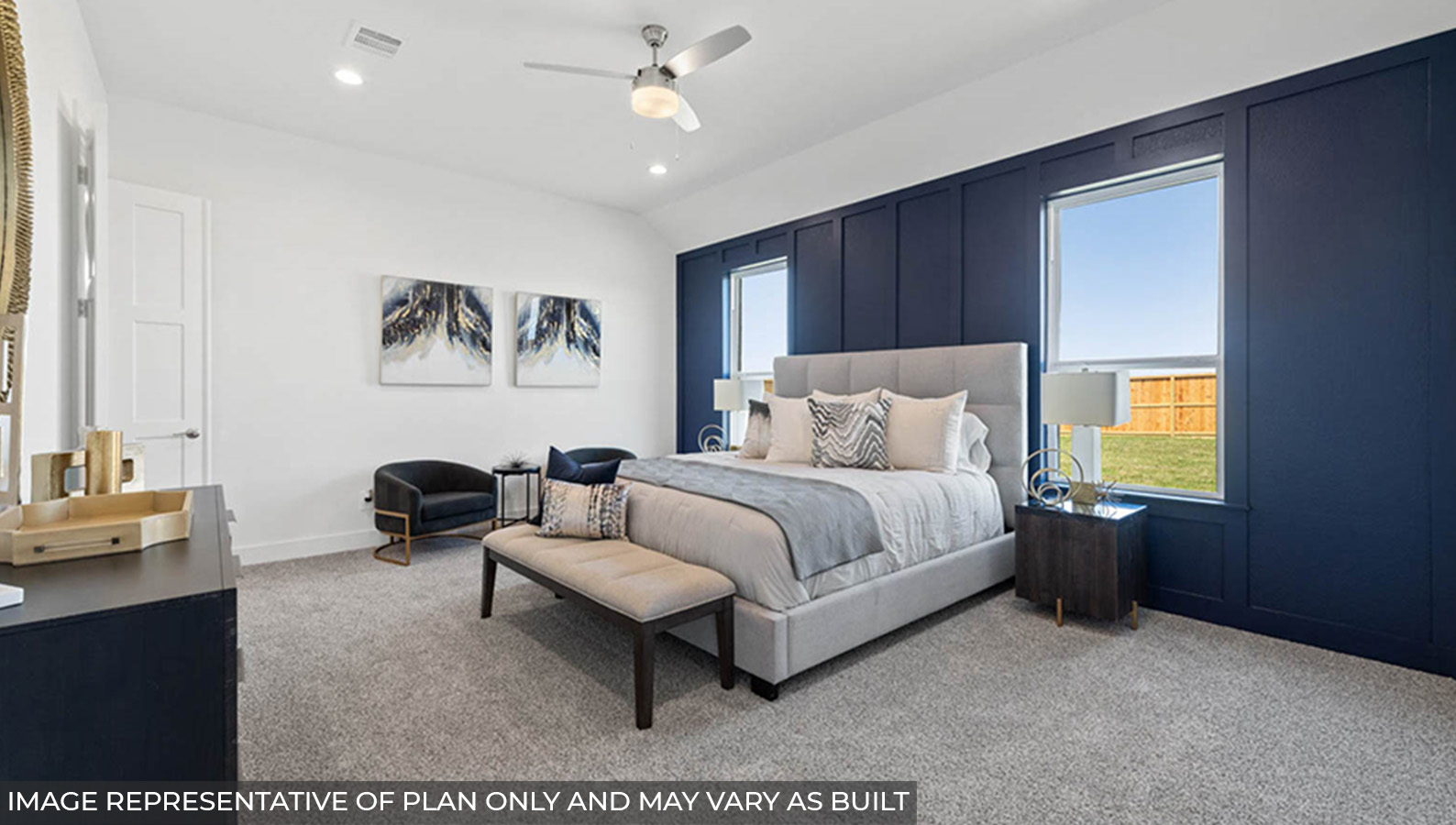 Primary bedroom with carpet flooring, a ceiling fan, and bright windows.