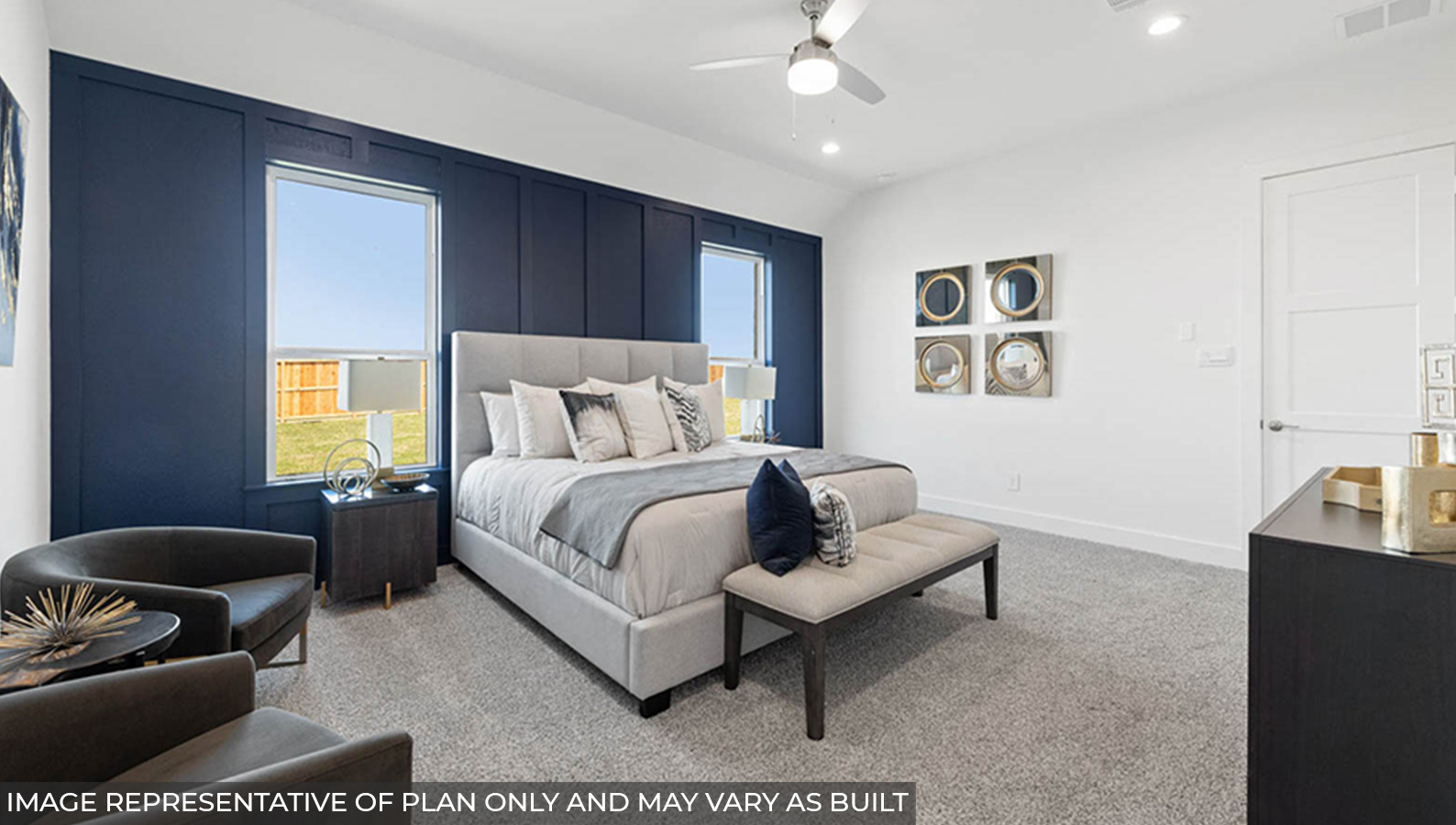 Primary bedroom with carpet flooring, a ceiling fan, and bright windows.