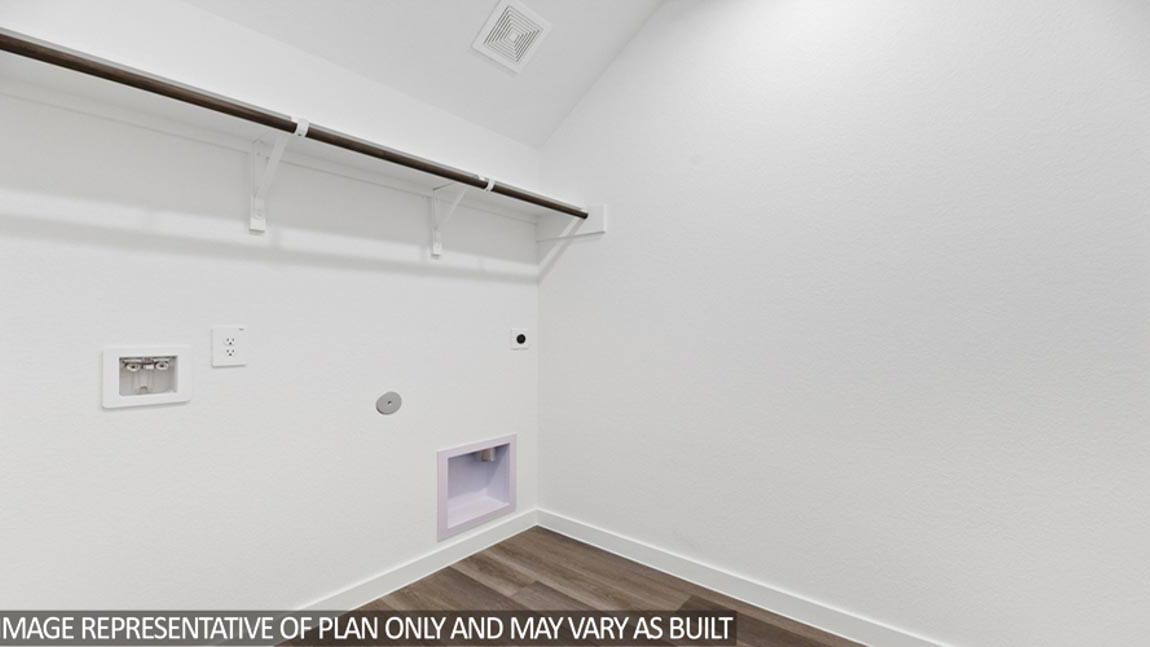 Utility room with vinyl flooring and overhead storage space.