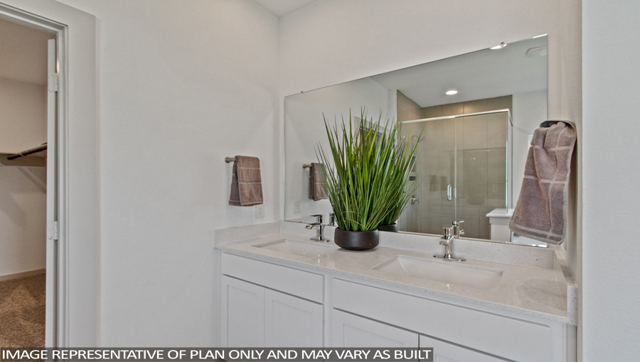 Staged primary bathroom with vinyl flooring and a double sink.