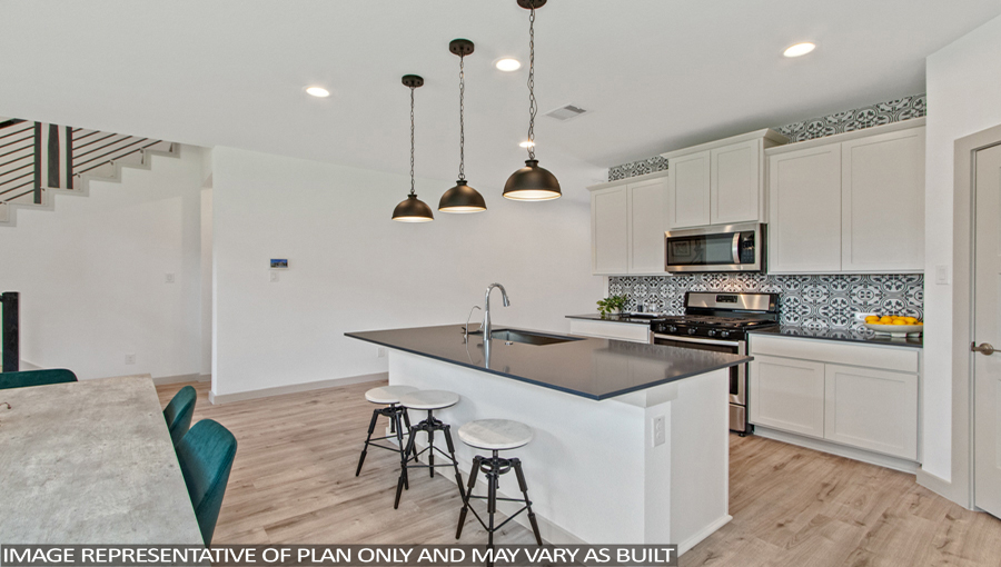 Staged kitchen with stainless-steel appliances and an island.