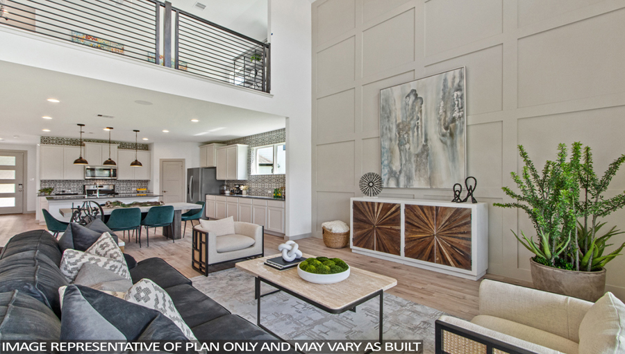 Staged open concept living and dining area with vinyl flooring and bright windows.