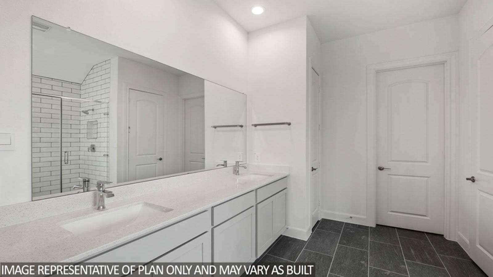 Primary bathroom with a double sink, a separate toilet room, and a spacious walk-in closet.