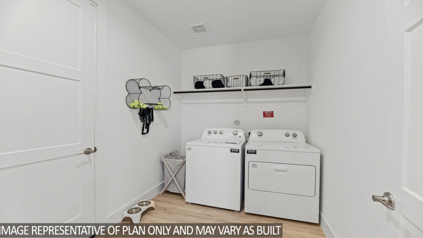 Utility room with vinyl flooring and overhead storage space.